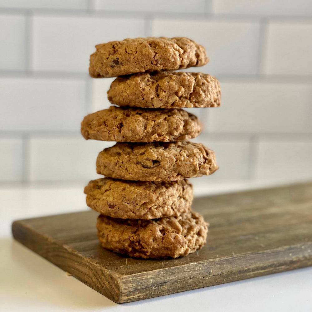 
                  
                    A photo of 6 cowgirl cookies arranged into a vertical tower, on top of a wood slab.
                  
                